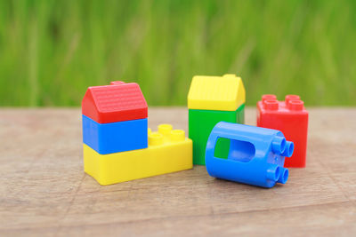 Close-up of toys on wooden table against plants