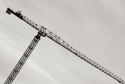 Low angle view of crane against sky