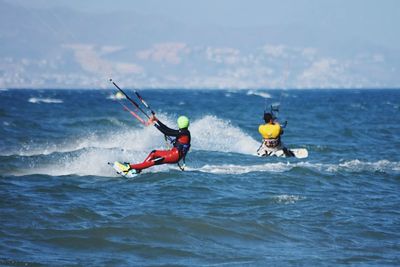 People in sea against sky