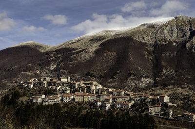 Town by mountain against sky