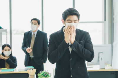 Young man standing in front of office