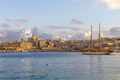 View of boats in sea against buildings, valletta, malta