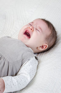 Cute baby girl lying on bed