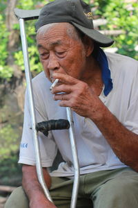 Midsection of man holding while sitting outdoors