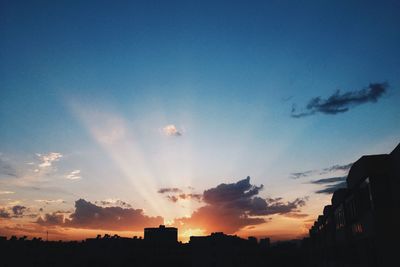 Low angle view of silhouette buildings at sunset