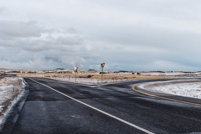 Road leading towards cloudy sky