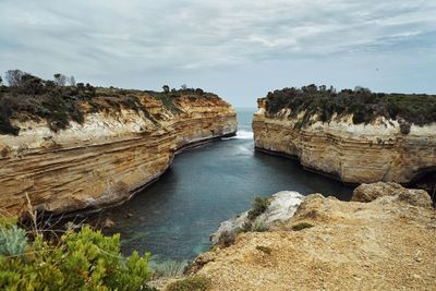 Rock formations by sea against sky