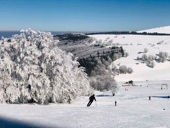 People walking on snow covered mountain against sky
