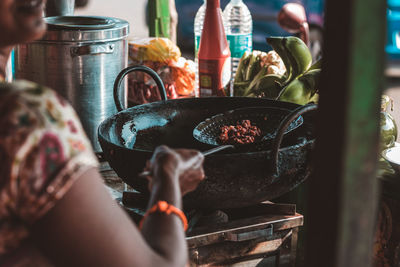 Midsection of woman preparing food at stall