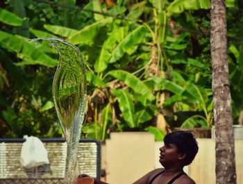 Man splashing water against trees