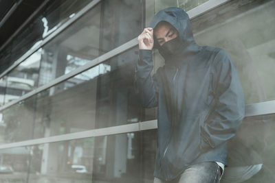 Man standing by glass wall