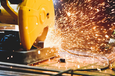 Close-up of electric saw cutting metal in factory