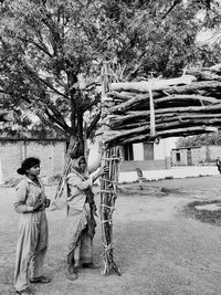 People standing by tree on field