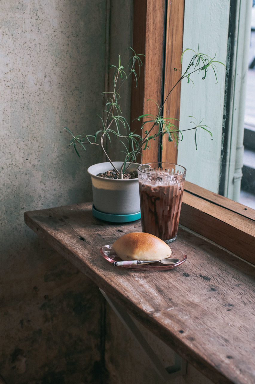 POTTED PLANT ON TABLE BY WINDOW