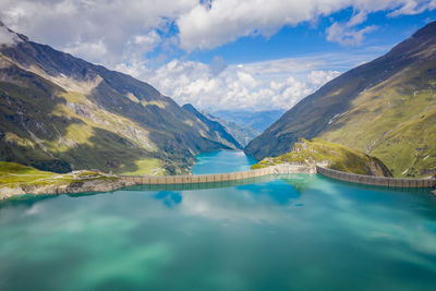 Scenic view of lake and mountains against cloudy sky