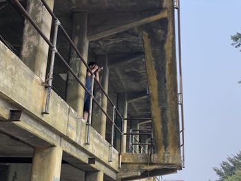 Low angle view of man standing on staircase against building