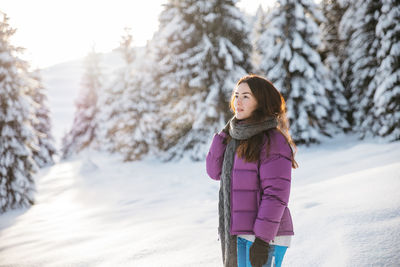 Young woman standing on snow covered field