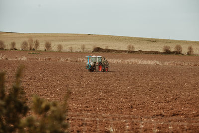 Tractor in desert against clear sky