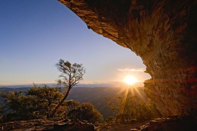 Scenic view of rock against sky at sunset