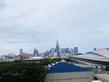 Buildings in city against cloudy sky