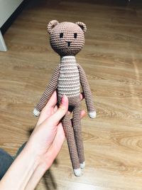 High angle view of hand holding toy on hardwood floor