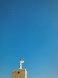 Low angle view of statue against clear blue sky