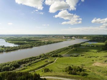 Scenic view of river amidst field against sky