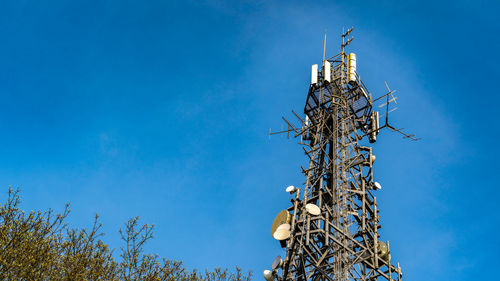 Shot of communications tower hosting various antennas and dishes