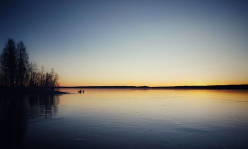 Scenic view of lake against clear sky during sunset