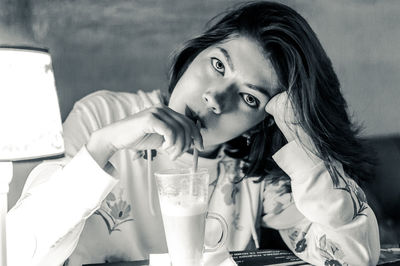 Portrait of a young woman drinking glass