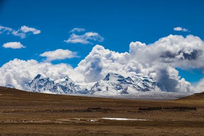 Scenic view of snowcapped mountains against blue sky