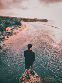 Rear view of man standing at beach