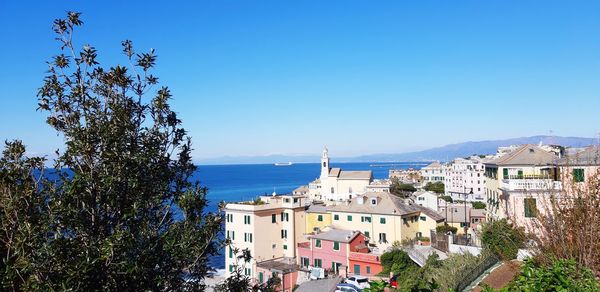 Panoramic view of city by sea against clear blue sky