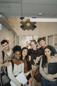 Portrait of happy multiracial male and female students at university