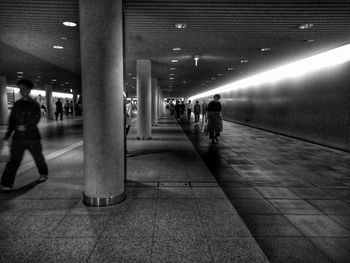 People walking in illuminated underground walkway