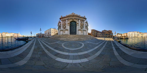 Fish-eye view of building in city against clear blue sky