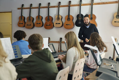 Teenagers attending keyboard lesson