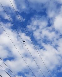 Low angle view of airplane flying against sky