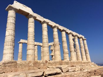 Low angle view of columns against clear blue sky