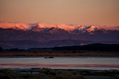 Scenic view of snowcapped mountains against sky during sunset