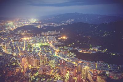 High angle view of illuminated cityscape against sky at night