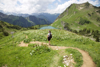 Rear view of woman standing on mountain trail