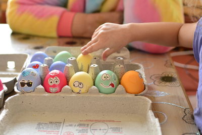 Cropped hand of woman playing with toys on table