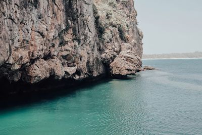 Rock formation in sea against sky