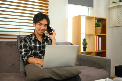 Young woman using laptop at home