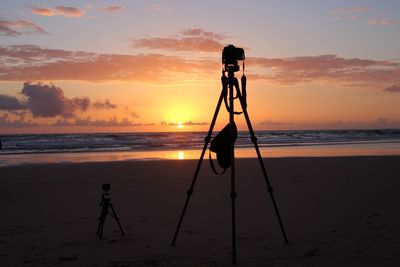 Silhouette of a tripod on the beach on sunset 