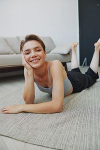 Portrait of young woman sitting on bed at home