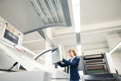 Female expertise using printing machine in workshop