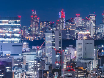 Illuminated cityscape against sky at night