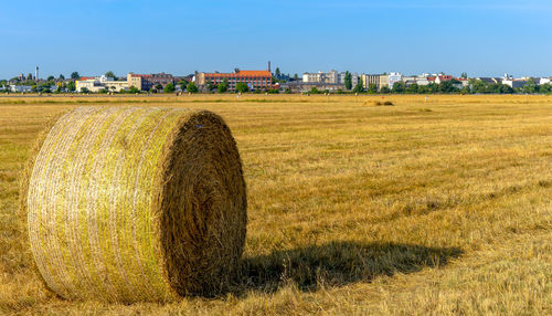 Hay bales on field against sky